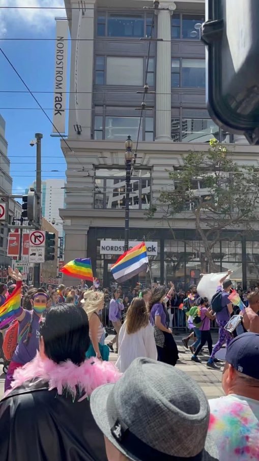 someone holding a flag at a pride parade that can easily be mistaken for a pride flag but is actually the flag of the Republic of China from 1912-1928